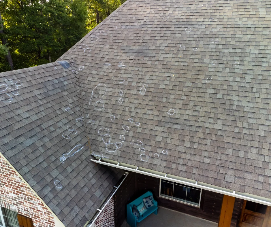 Shingle roof with chalk-marked areas during a hail damage assessment