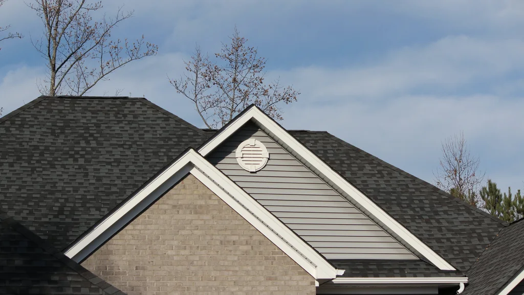 Architectural shingle roof with intersecting gables on a brick home