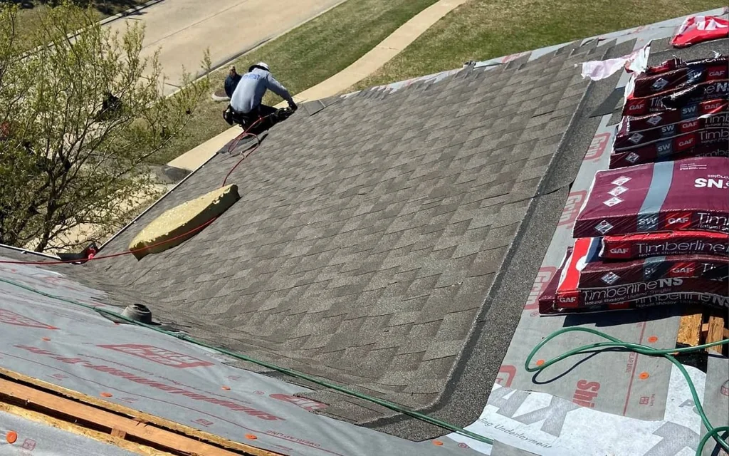 Roofing work in progress on an asphalt shingle roof